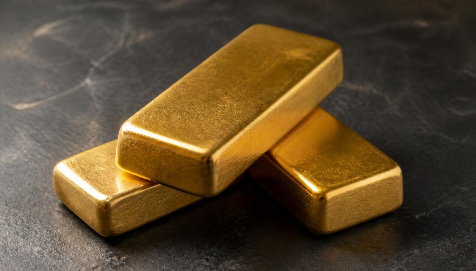 Gestapelte Feingoldbarren 999,9 auf dunklem Stein, Symbolbild für Gold günstig kaufen